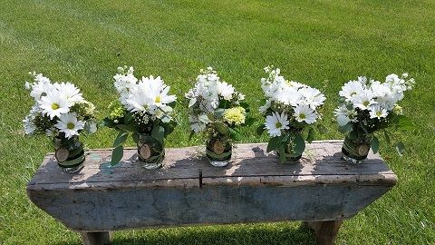  These beautiful bouquets were designed in Mason Jars with monogrammed wooden circles.