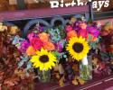 Large sunflowers with orange and pink roses, fragrant stock and eucalyptus.
