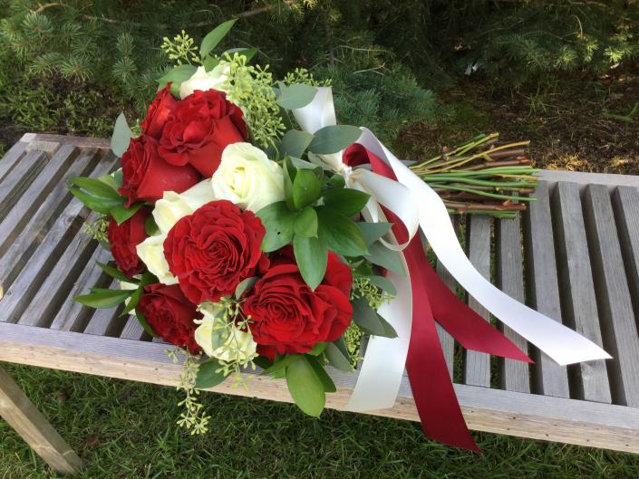 Deep red "heart" roses designed with white roses, seeded eucalyptus and israeli ruscus.