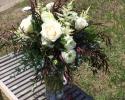 White roses and ranunculus, astilbe and a variety of eucalyptus.