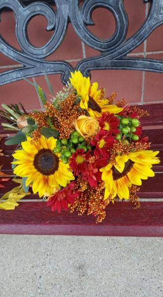  Rust sunflowers, tinted solidago, fall mums and green hypericum berries.