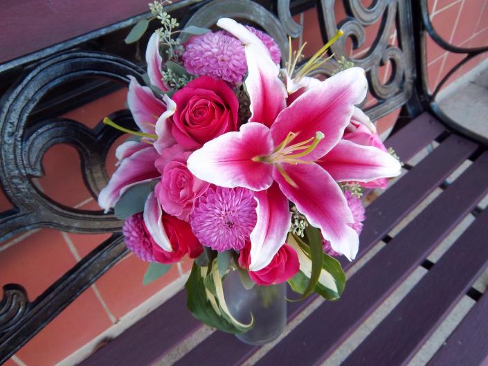 Locally grown hot pink dahlias, hot pink roses, stargazer lilies, accented with hosta leaves.