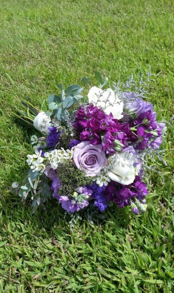 Shades of purple, roses, stock, trachillium, lisianthus, eucalyptus, statice and waxflower.