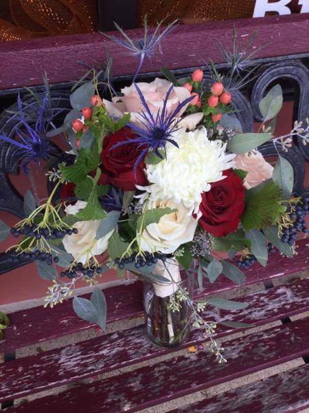 Thistle, viburnum berries, champagne, ivory and deep red roses, peach hypericum berries.