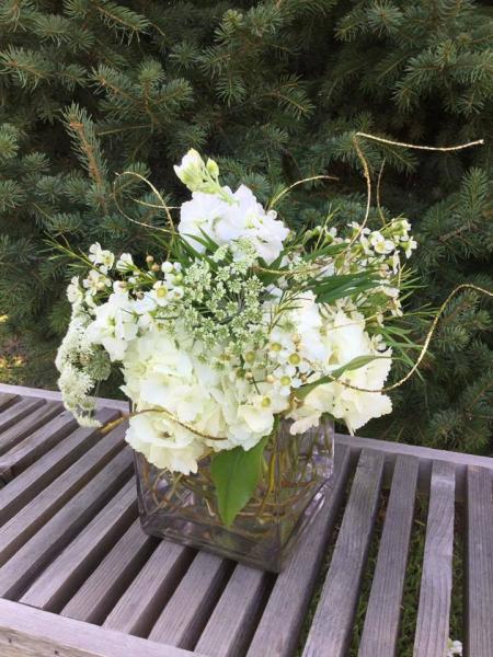Designed with hydrangea, queen annes lace, waxflower, stock and roses.