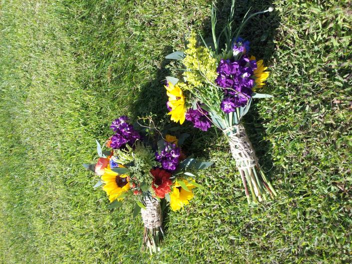 Sunflowers, dark purple stock, solidago, blue delphinium and accented with a unique burlap ribbon.