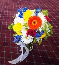 Yellow roses, orange gerbera daisies, blue delphinium.