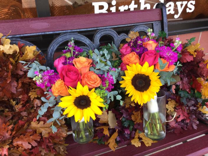 Large sunflowers with orange and pink roses, fragrant stock and eucalyptus.