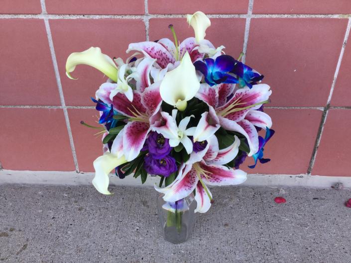 Miniature white calla lilies, bright blue and white dendrobium orchids, stargazer lilies, purple lisianthus.