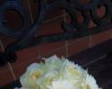  Pale yellow roses, ivory minature gerbera daisies accented with white satin ribbon.