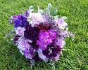 Shades of purple roses, stock and carnations. Bright blue delphinium, limonium and verigated pittsoporum.